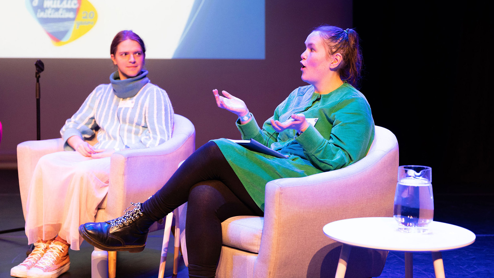 Malin Lewis on the right and Geraldine Heaney on the left, seated on armchairs during an event onstage