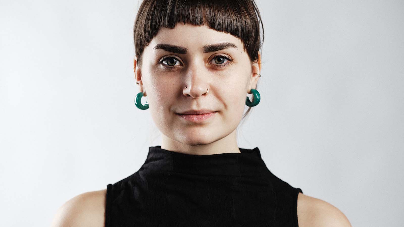 A woman with brown hair and a fringe, wearing a sleeveless black turtleneck top. This is Amy Laurenson.