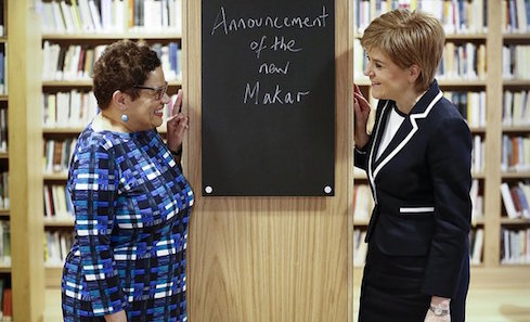 Makar Jackie Kay stands in a library with Nicola Sturgeon, First Minister